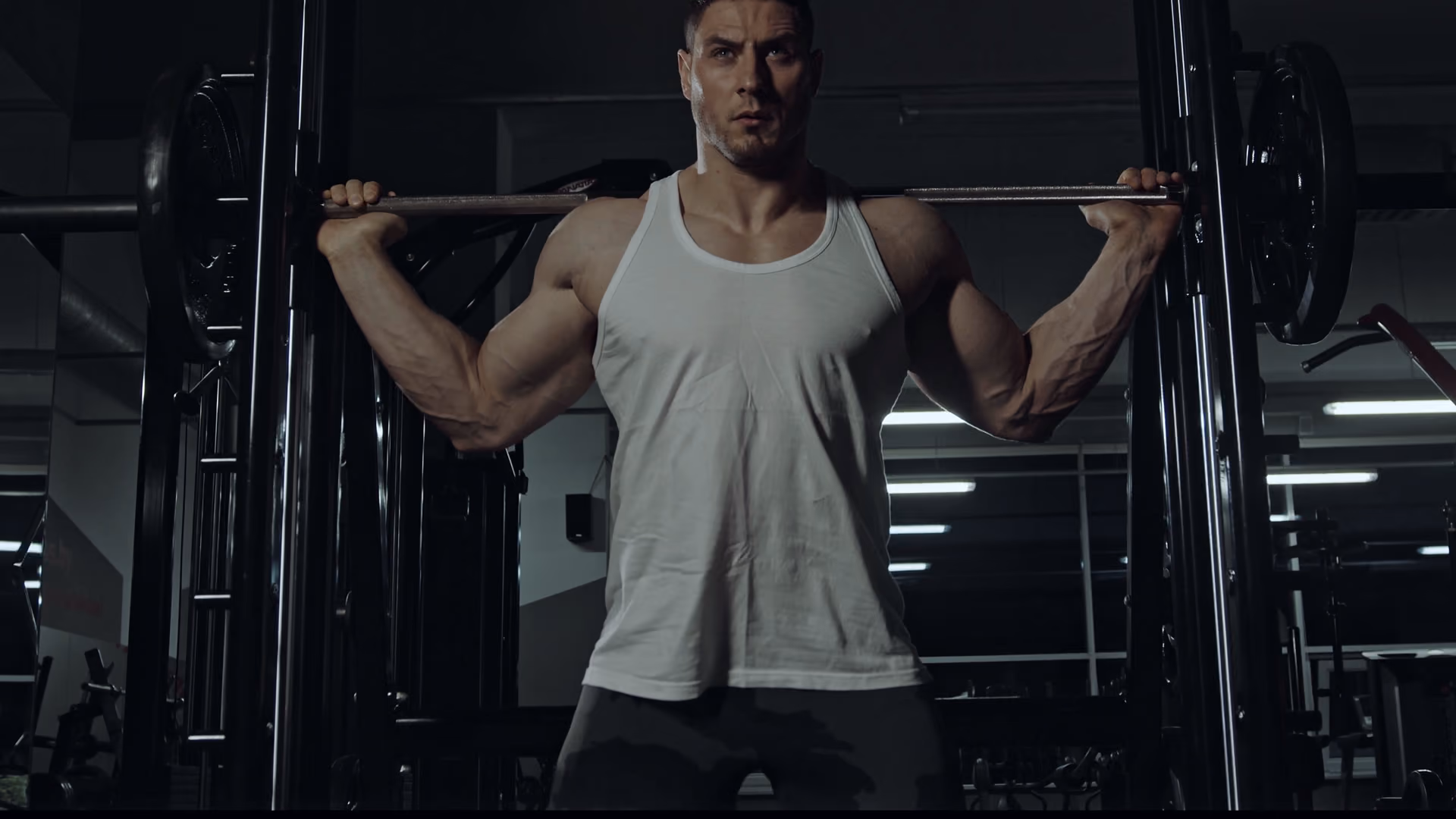 An athlete squatting in a dark gym